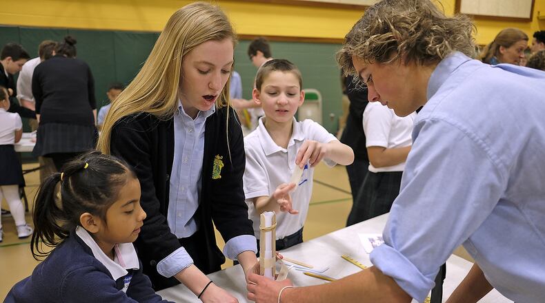 Catholic Central students, from left, Arianna Bravo, Kirsten Beals, Shane Fischer and Wil Hoffman try to build a tower thet will hold a tennis ball Thursday during the school’s Irish STEM Day. Bill Lackey/Staff