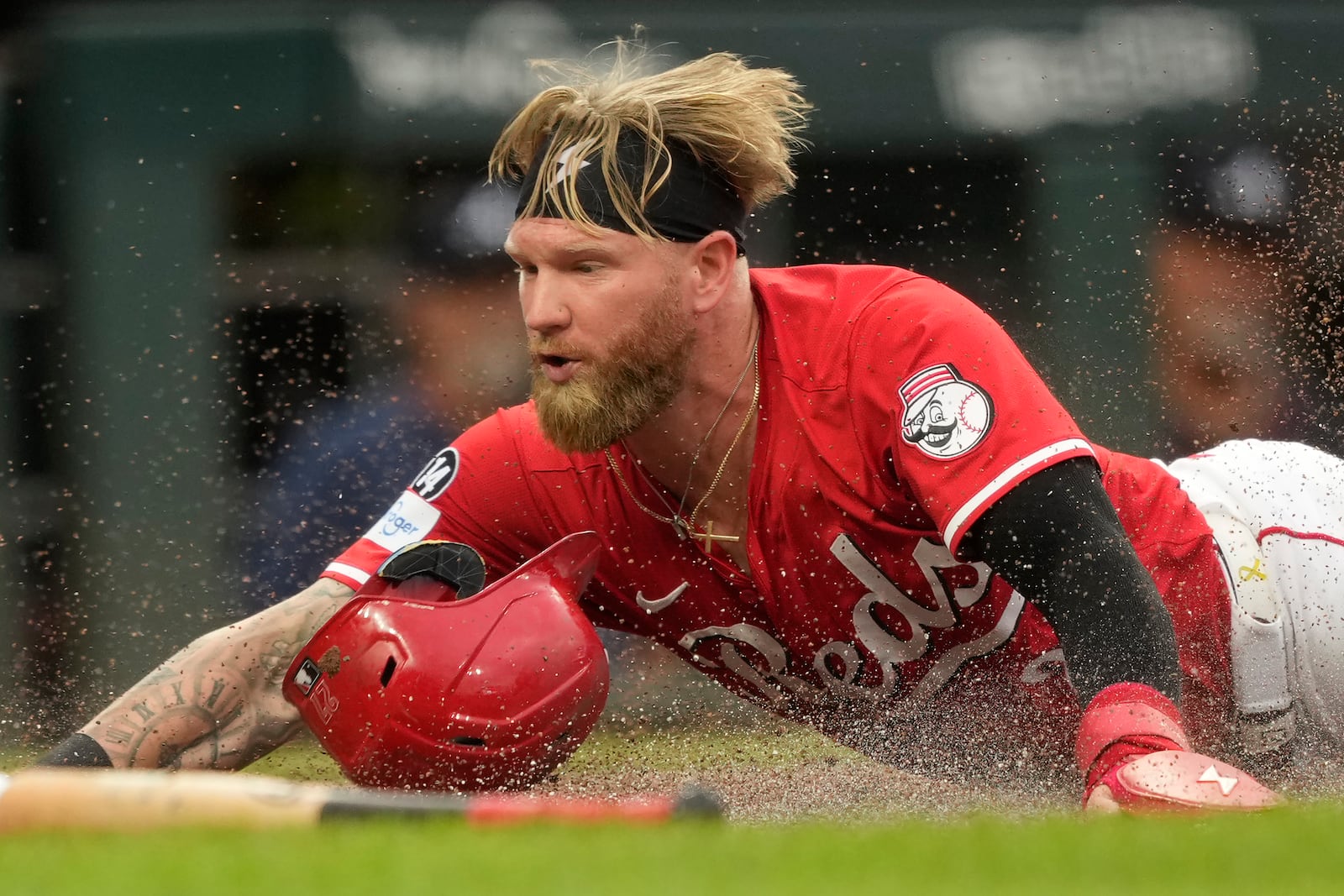 Cincinnati Reds' Jake Fraley dives safely into home plate to score on a double hit by Tyler Stephenson during the second inning of a baseball game against the Atlanta Braves, Thursday, July 31, 2025, in Cincinnati. (AP Photo/Carolyn Kaster)