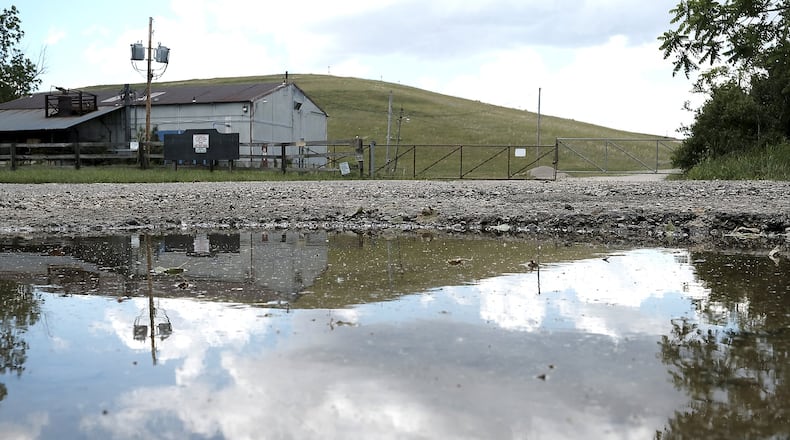 The Tremont City Barrel Fill is reflected in a puddle Wednesday, June 1, 2017. Bill Lackey/Staff