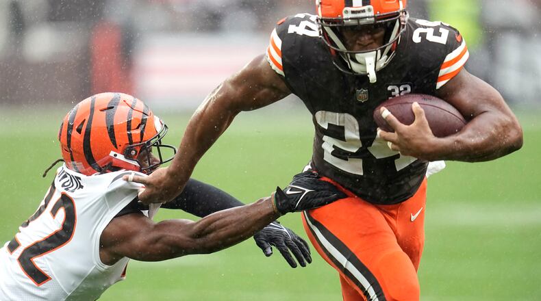 Cleveland Browns running back Nick Chubb (24) is grabbed by Cincinnati Bengals cornerback Chidobe Awuzie (22) on a run during the first half of an NFL football game Sunday, Sept. 10, 2023, in Cleveland. (AP Photo/Sue Ogrocki)