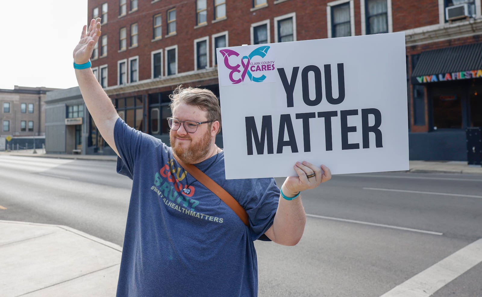 Andrew Ferguson holds up a sign with a positive message as part of an event held by a suicide prevention task force, Clark County Cares, to raise awareness of Suicide Prevention Awareness Month on Tuesday, September 16, 2025, in Springfield. JOSEPH COOKE/STAFF