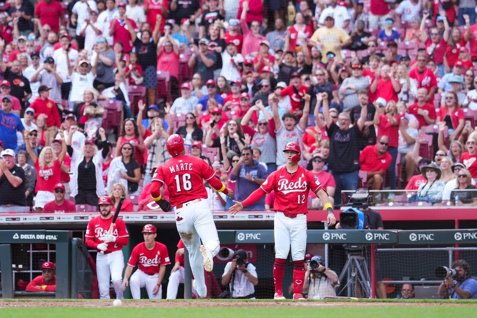 Cincinnati Reds' Noelvi Marte (16) celebrates with teammate Austin Hays (12) after scoring on a double hit by Elly De La Cruz during the sixth inning of a baseball game against the New York Mets, Sunday, Sept. 7, 2025, in Cincinnati. (AP Photo/Jeff Dean)