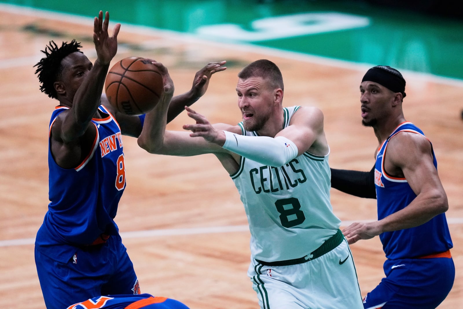 Boston Celtics center Kristaps Porzingis (8) passes the ball while pressured by the New York Knicks during the first half of Game 1 of an NBA basketball second-round playoff series Monday, May 5, 2025, in Boston. (AP Photo/Charles Krupa)