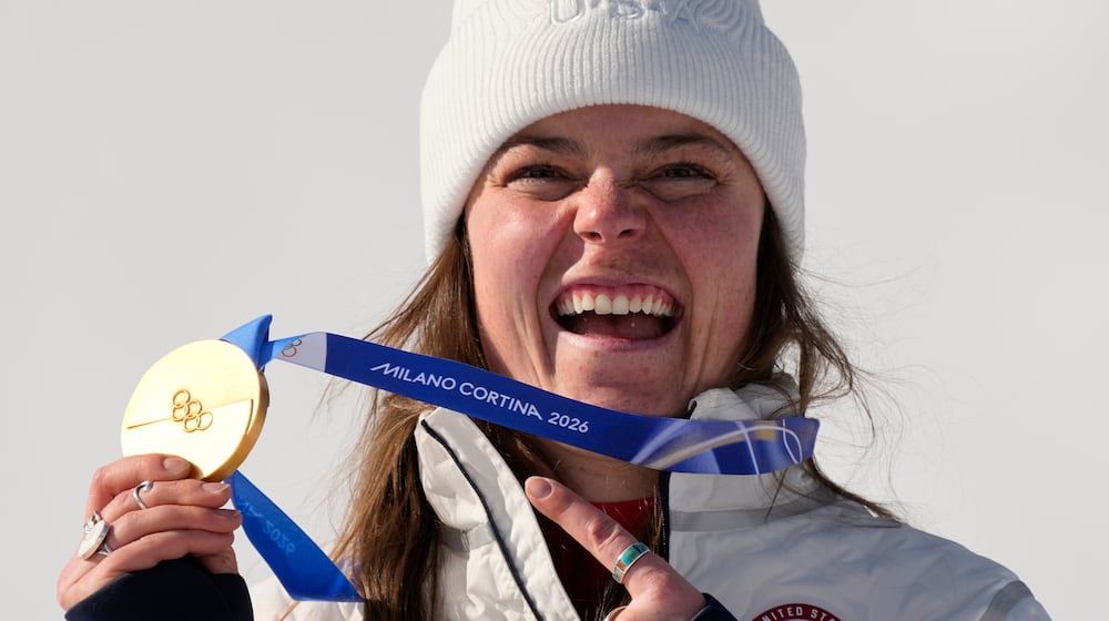 United States' Breezy Johnson shows her gold medal in the alpine ski women's downhill race, at the 2026 Winter Olympics, in Cortina d'Ampezzo, Italy, Sunday, Feb. 8, 2026. (AP Photo/Andy Wong)