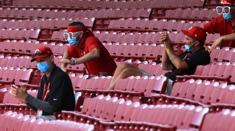 Reds groundskeepers cheer during a game against the Tigers on Sunday, July 26, 2020, at Great American Ball Park in Cincinnati. David Jablonski/Staff