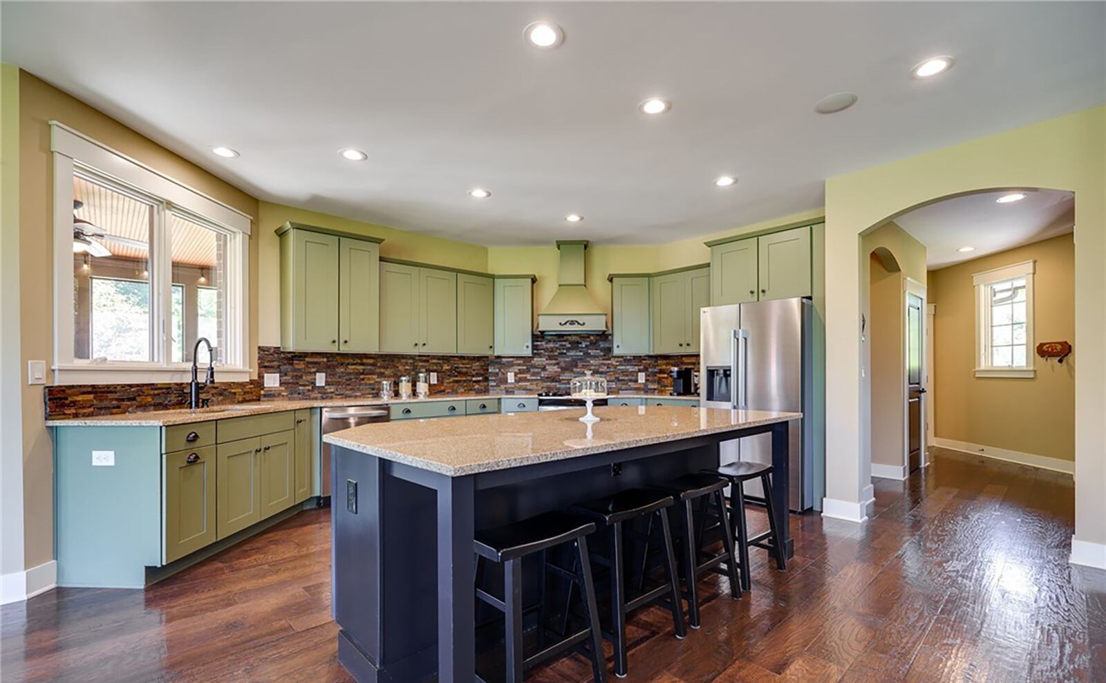 The kitchen has hardwood floors, recessed lighting, custom cabinets and a gas range, dishwasher, side by side refrigerator and microwave. There is also an island with bar seating. CONTRIBUTED