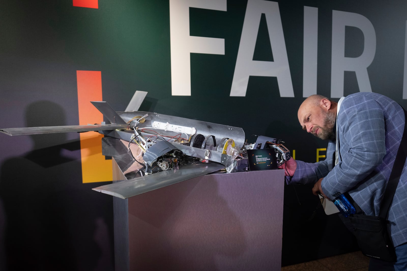 A visitor examines a damaged drone made by Russia with western components during the International Conference on Expanding Sanctions Against Russia in Kyiv, Ukraine, Friday, June 27, 2025. (AP Photo/Efrem Lukatsky)