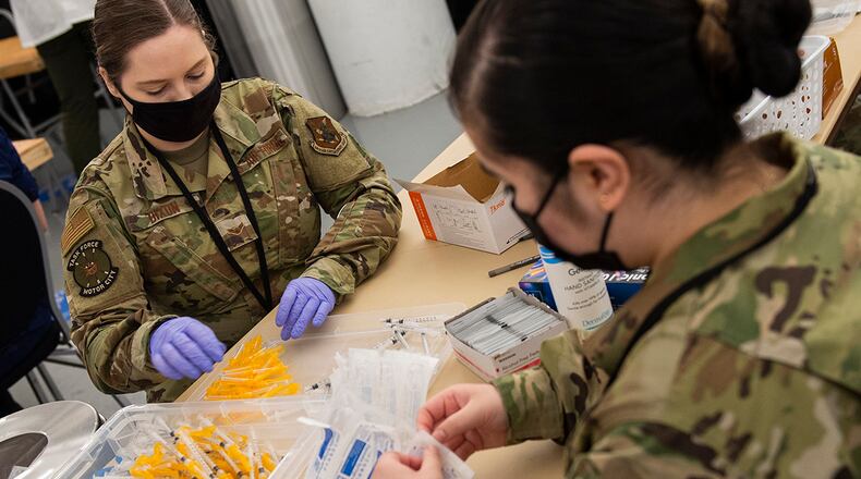 Airmen assemble syringes for use in distribution of the COVID-19 vaccine inside the pharmacy area of community vaccination center at Ford Field in Detroit on May 3. U.S. AIR FORCE PHOTO/WESLEY FARNSWORTH