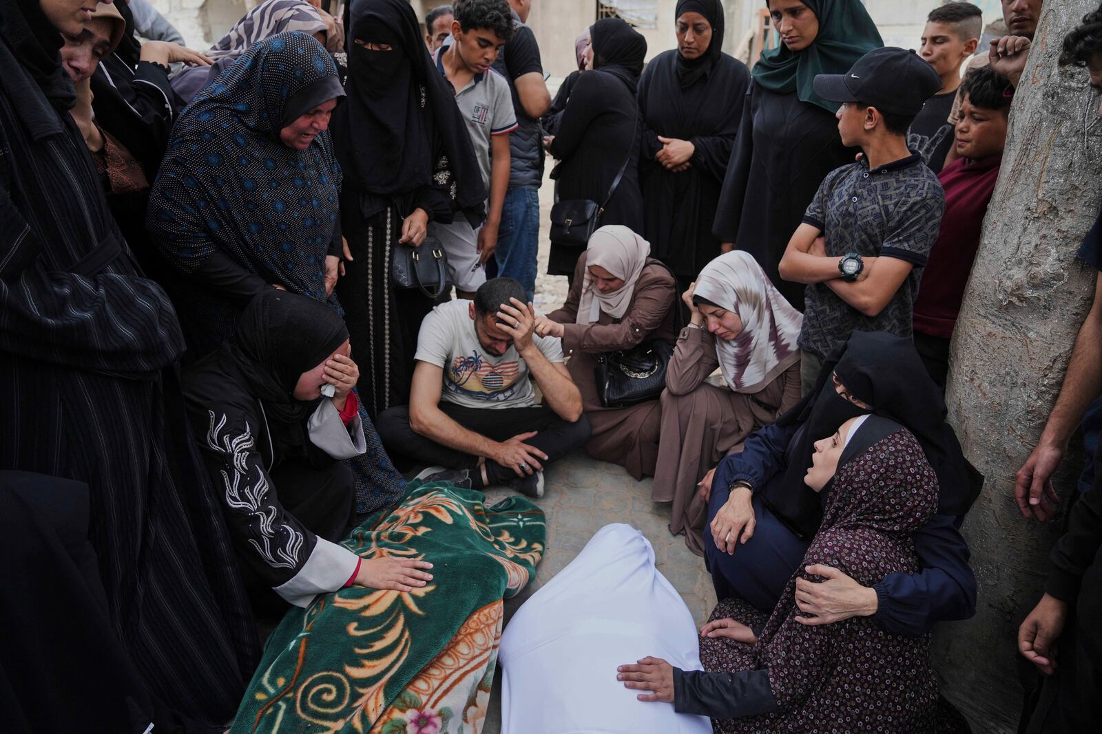 Relatives grieve over the bodies of members of the Jalis and Al-Sharbasi families, killed in an Israeli army airstrike on Yaffa School in Gaza City, Wednesday, April 23, 2025. (AP Photo/Jehad Alshrafi)