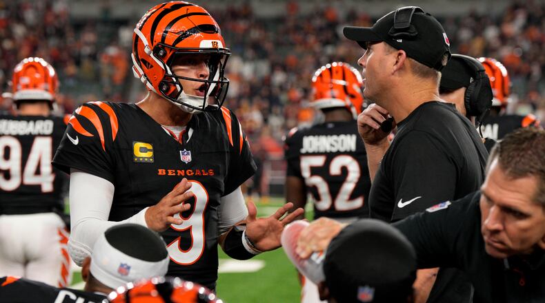 Cincinnati Bengals quarterback Joe Burrow (9) talks with head coach Zac Taylor, right, during the second half of an NFL football game against the Washington Commanders, Monday, Sept. 23, 2024, in Cincinnati. The Commanders won 38-33. (AP Photo/Jeff Dean)