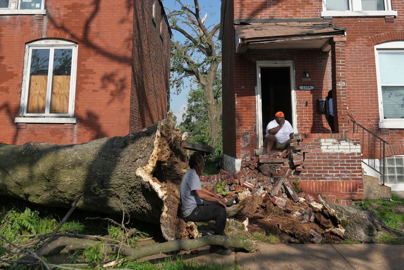 People survey damage after a severe storm moved through Friday, May 16, 2025, in St. Louis. (AP Photo/Jeff Roberson)