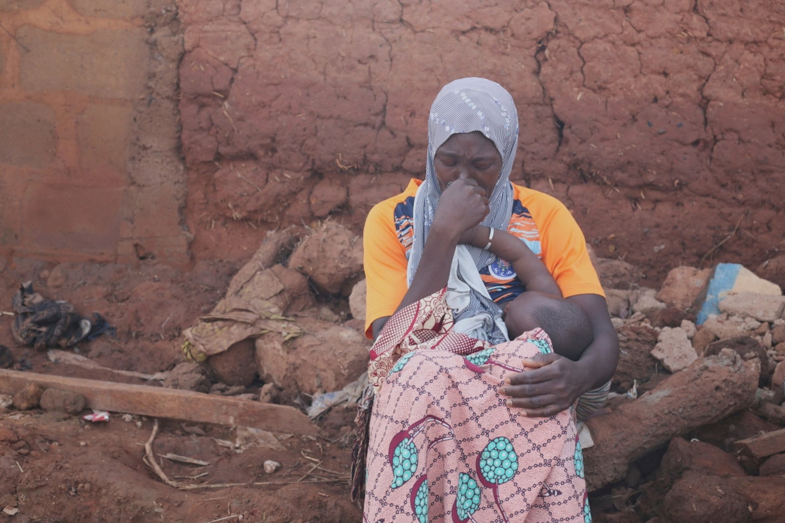 A woman sits in a flooded area after heavy rainfall in the market town of Mokwa, north-central Nigeria, Saturday May 31, 2025. (AP Photo/Usman Salihu Mokwa)