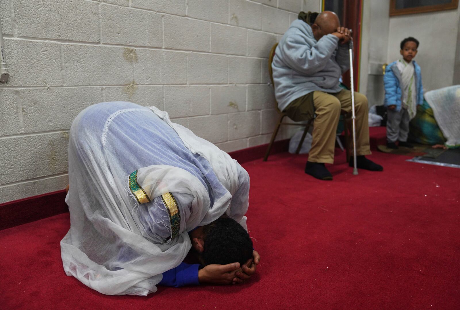 A congregant kneels to pray during a service at Re'ese Adbarat Debre Selam Kidist Mariam Church, an Ethiopian Orthodox Tewahedo church, in Washington, D.C., Saturday, April 5, 2025. (AP Photo/Jessie Wardarski)