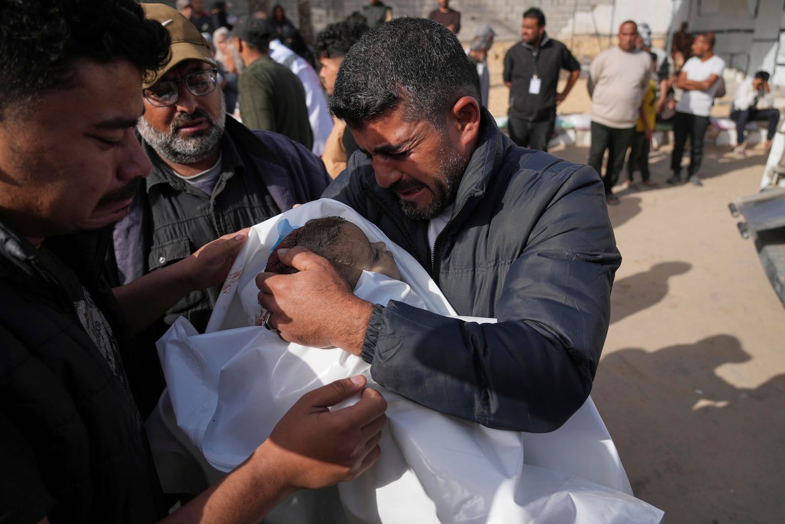 Mohannad Al-Agha, holds body of his niece Zeina Al- Agha, 2, killed in an overnight Israeli airstrike, during her funeral at Nasser Hospital in Khan Younis, Gaza Strip, Sunday, May 11, 2025. (AP Photo/Abdel Kareem Hana)