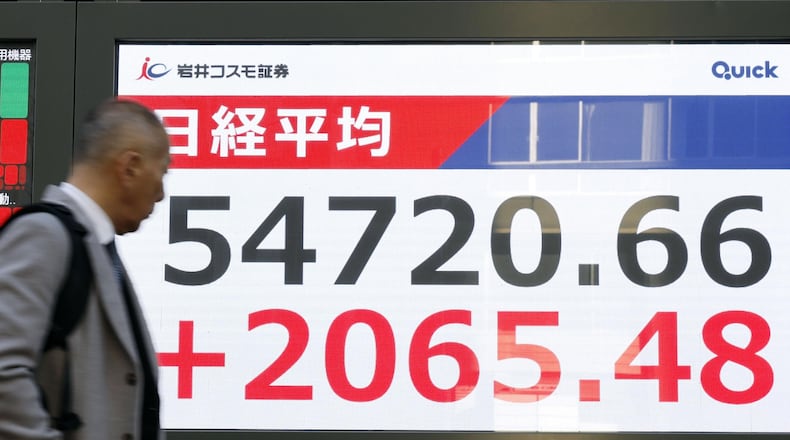 A person walks in front of an electronic stock board at a securities firm in Tokyo Tuesday, Feb. 3, 2026. (Masanori Kumagai/Kyodo News via AP)