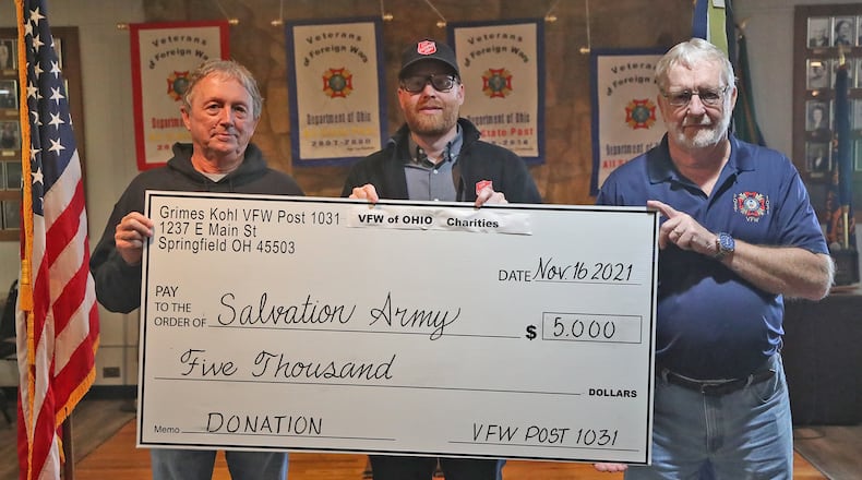 Members from the VFW Post 1031, Rick Boop, post commander, left, and Bobby Crabtree, senior vice commander, right, presented Ryan Ray, from the Springfield Salvation Army with a $5,000 check Thursday. The Salvation Army was just one of the local charities the VFW helped this week that totalled $25,000. BILL LACKEY/STAFF