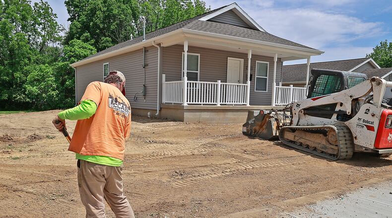 A worker from McCabe Property Services gets the ground around a new Habitat for Humanity house at 1122 W. Perrin Avenue ready for grass Thursday, May 25, 2023. BILL LACKEY/STAFF