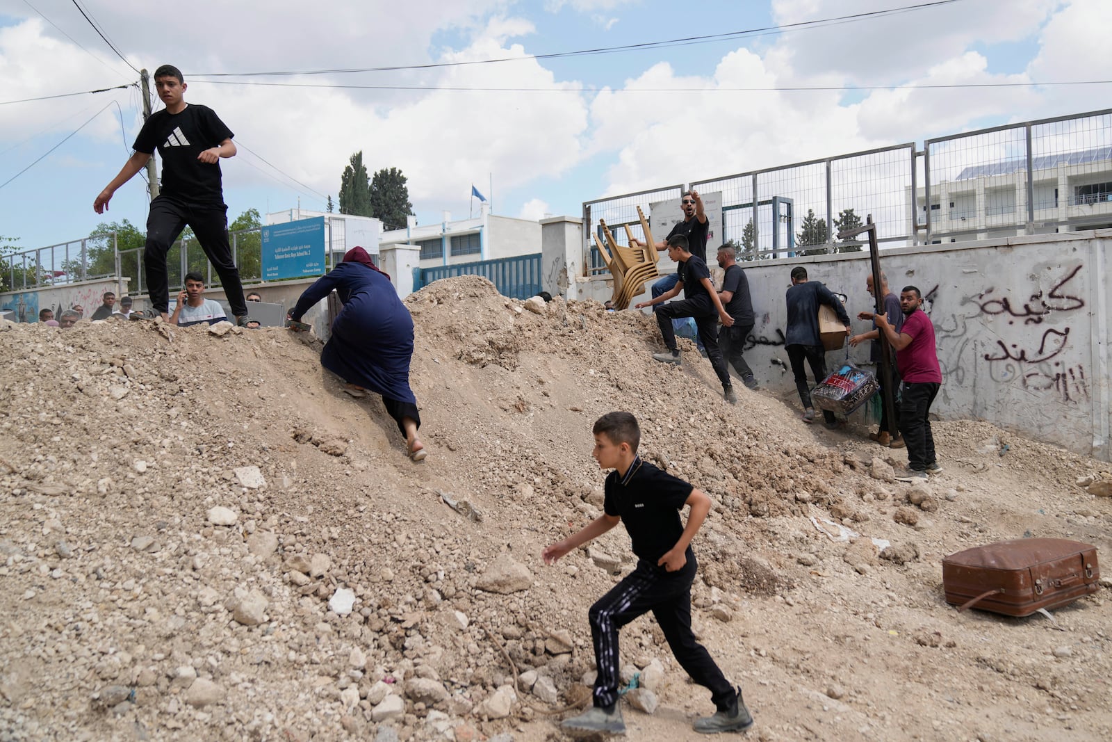 Residents of the now evacuated refugee camp of Tulkarem return to collect belongings before the destruction of their homes as Israeli forces prepare to carry out the demolition of 116 homes across the two refugee camps of the Israeli occupied West Bank city of Tulkarem, Friday, May 2, 2025. (AP Photo/Nasser Nasser)