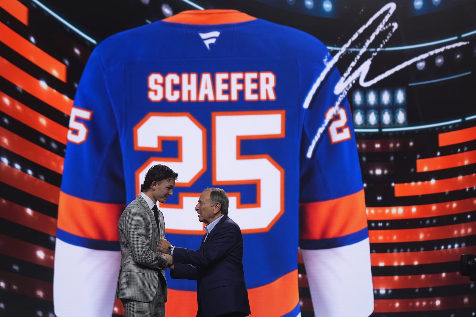 Matthew Schaefer, left, stands with NHL commissioner Gary Bettman after being drafted by the New York Islanders during the NHL hockey draft Friday, June 27, 2025, in Los Angeles. (AP Photo/Damian Dovarganes)