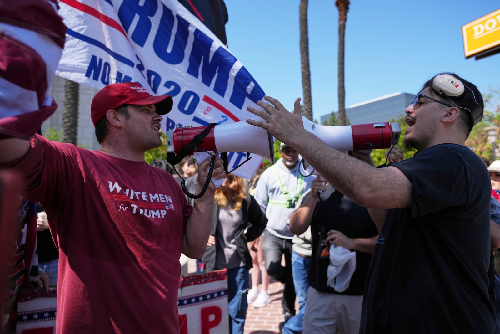 A protester wearing a shirt reading "WHITE MEN for TRUMP" argues with another protester Tuesday, June 10, 2025, in Santa Ana, Calif. (AP Photo/Jae C. Hong)