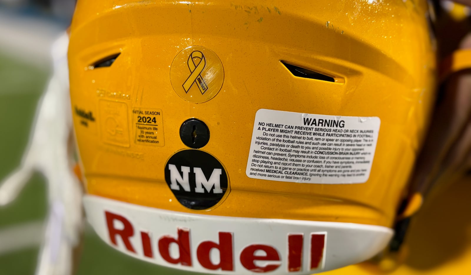 Alter's helmets show the initials of Nick Mangold, the Alter graduate who died Oct. 25 of kidney disease, during a game against Bellbrook on Friday, Oct. 31, 2025, at Roush Stadium in Kettering. David Jablonski/Staff