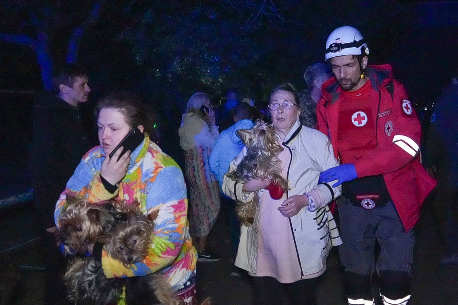 In this photo provided by the Ukrainian Emergency Service, a rescuer helps evacuate residents from their damaged house following Russia's air raid in Odesa, Ukraine, Thursday, May 1, 2025. (Ukrainian Emergency Service via AP)