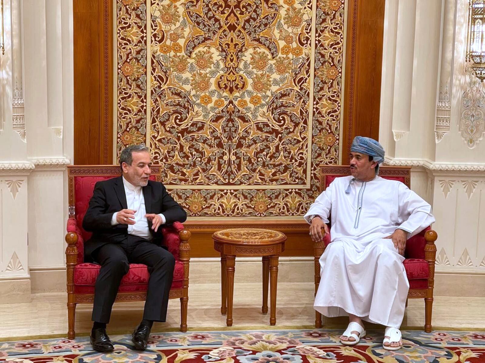 In this photo released by Iranian Foreign Ministry, Iranian Foreign Minister Abbas Araghchi, left, speaks with an unidentified Omani official upon his arrival at Muscat, Oman, Friday, April 25, 2025, a day prior to negotiations with U.S. Mideast envoy Steve Witkoff. (Iranian Foreign Ministry via AP)