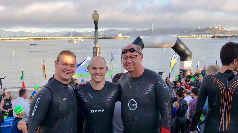 Steve Neely, right, and his sons Chris, 29, left, and Matt, 32, pictured just before they boarded the ferry to Alcatraz Island for their swim back to the San Francisco Aquatic Park. (Courtesy of the Neely family)