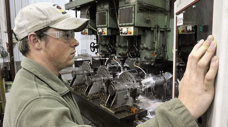 An employee at HDI Landing Gear in Springfield machines three pieces of metal in the background that will be used for airplane landing gear. Bill Lackey/Staff