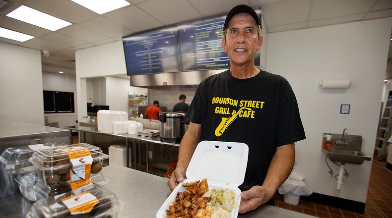 Hassan Abdalla, owner of the new Bourbon Street Grill & Cafe, with an bourbon chicken dinner Monday, July 8, 2024. BILL LACKEY/STAFF