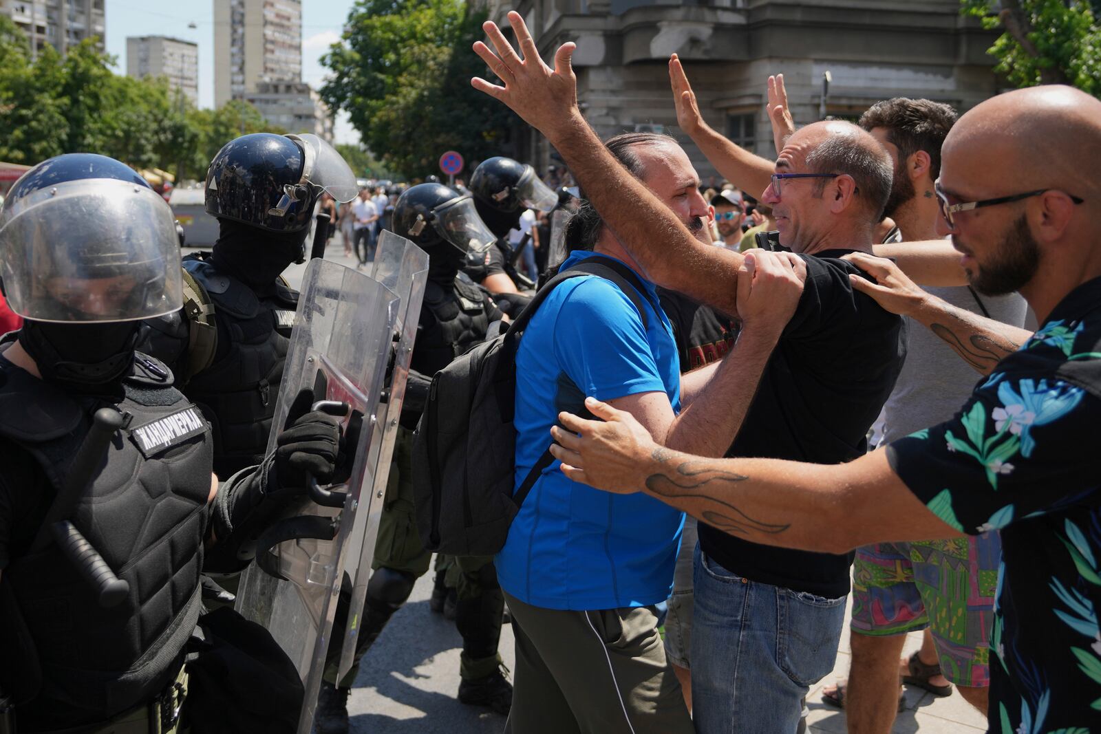 People react as Serbian gendarmerie officers remove a street blockade that was set up as part of a protest over a spate of arrests of anti-government protesters after a massive rally demanding an early parliamentary election in Belgrade, Serbia, Monday, June 30, 2025. (AP Photo/Darko Vojinovic)