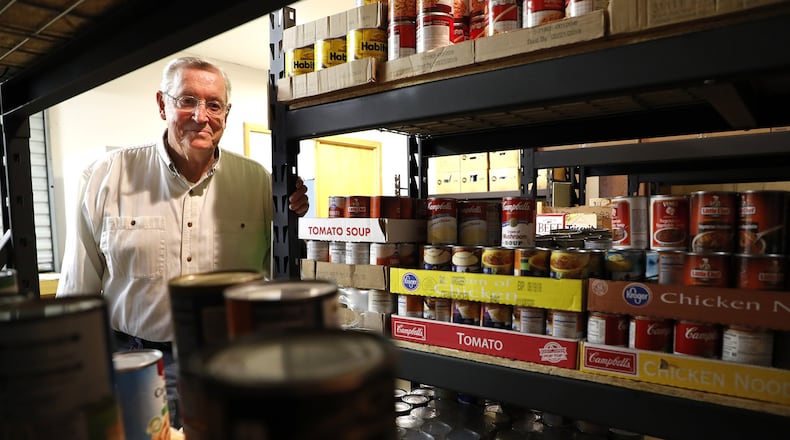 Bill Miller, the president of the Champaign County Memorial Foundation, looks over the food in the Oasis of Mercy Food Pantry in Mechanicsburg. Bill Lackey/Staff