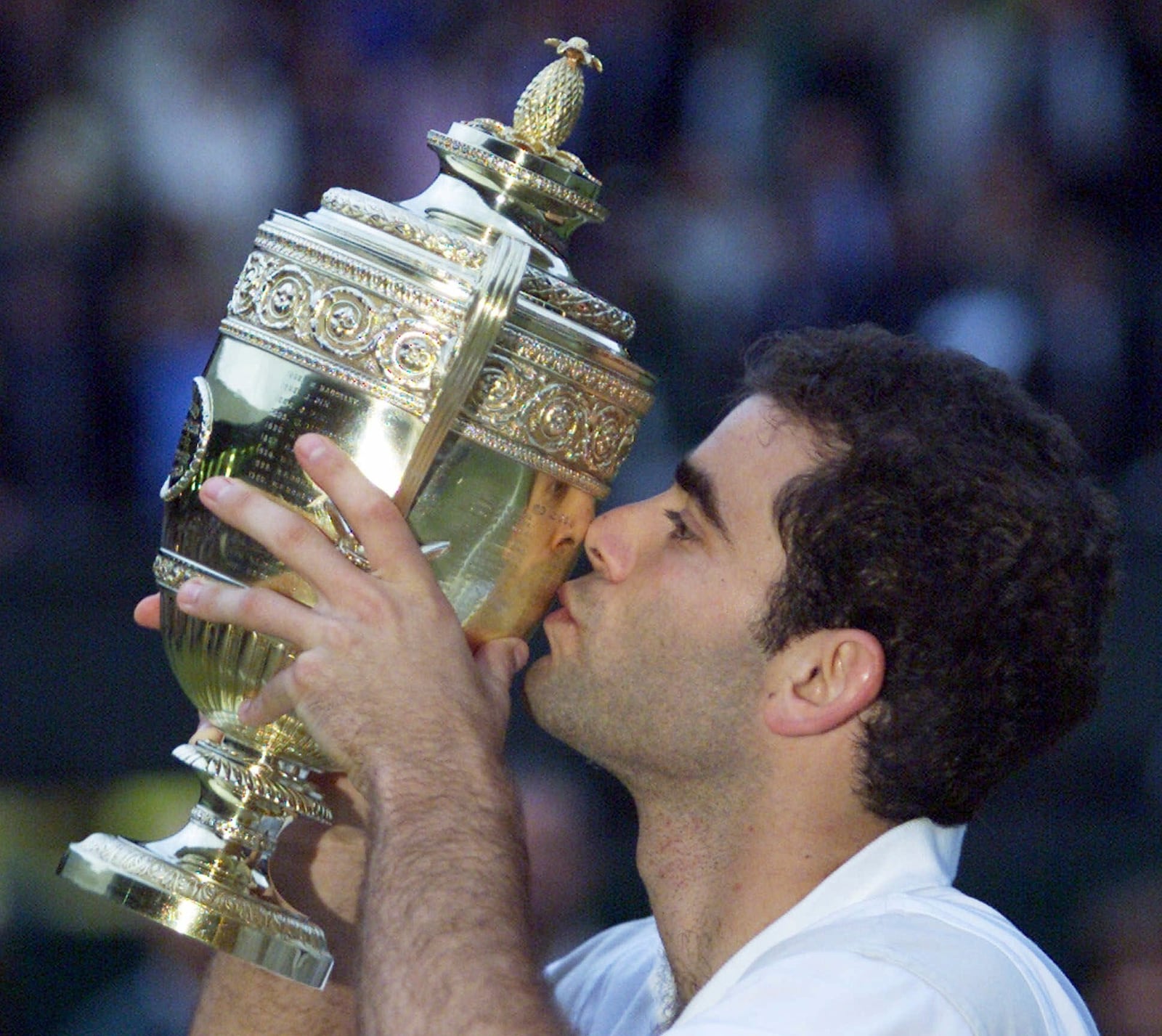 FILE - Pete Sampras kisses the trophy, after defeating Australia's Patrick Rafter in the Men's Singles final on the Center Court at Wimbledon Sunday, July 9, 2000. (AP Photo/Dave Caulkin,File)