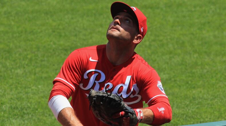 Reds first baseman Joey Votto chases a foul ball during a game against the Tigers on Sunday, July 26, 2020, at Great American Ball Park in Cincinnati. David Jablonski/Staff