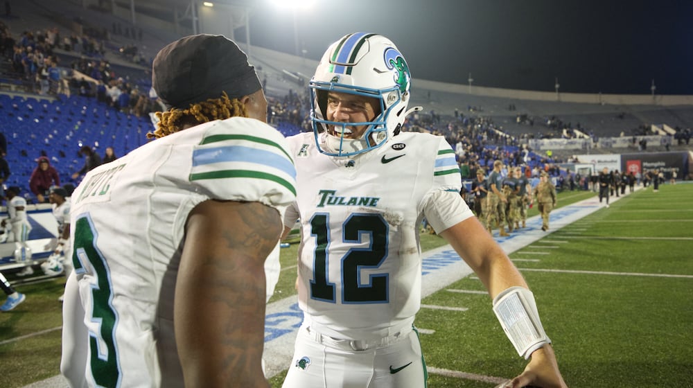 Tulane quarterback Jake Retzlaff (12) celebrates with Tulane defensive back Javion White (3) after defeating Memphis in an NCAA college football game, Friday, Nov. 7, 2025, in Memphis, Tenn. (AP Photo/Nikki Boertman)