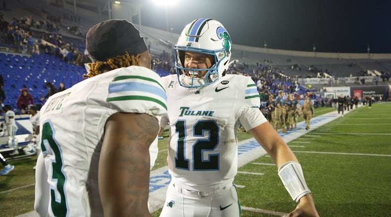 Tulane quarterback Jake Retzlaff (12) celebrates with Tulane defensive back Javion White (3) after defeating Memphis in an NCAA college football game, Friday, Nov. 7, 2025, in Memphis, Tenn. (AP Photo/Nikki Boertman)