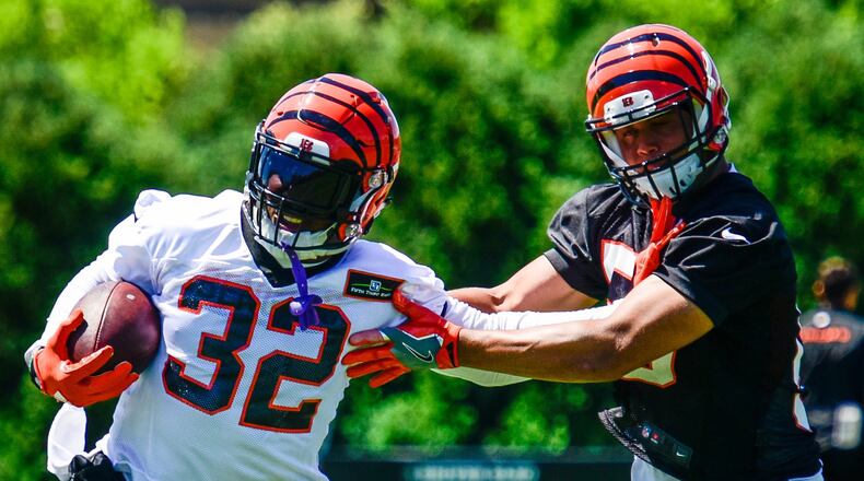 Cincinnati Bengals running back Jeremy Hill, left, stiff arms linebacker Jordan Evans during practice Tuesday, June 6, 2017, on the practice fields next to Paul Brown Stadium in Cincinnati. NICK GRAHAM/STAFF