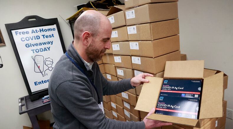 Nate Smith, from the Clark County Combined Health District, opens one of the hundreds of boxes filled with COVID-19 test kits Tuesday at the Health District office. The health department is giving away free test kits Wednesday from 8:30 a.m. to 4:30 p.m. Wednesday, Dec. 21, 2022, at their Home Road location. BILL LACKEY/STAFF