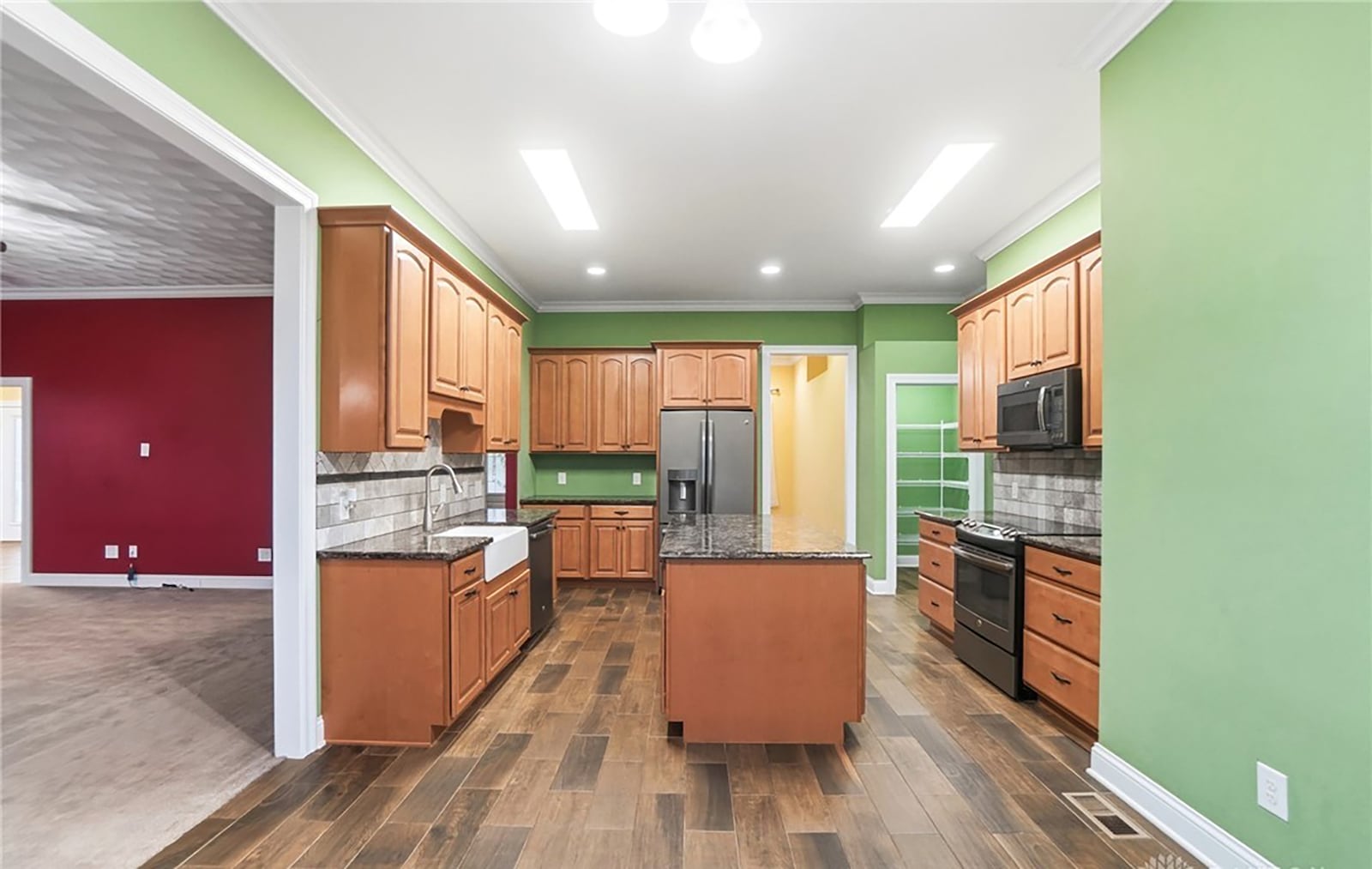 The kitchen has tile flooring, wood cabinets, an island, granite countertops, recessed lighting and a walk in pantry. There is also a breakfast nook. CONTRIBUTED