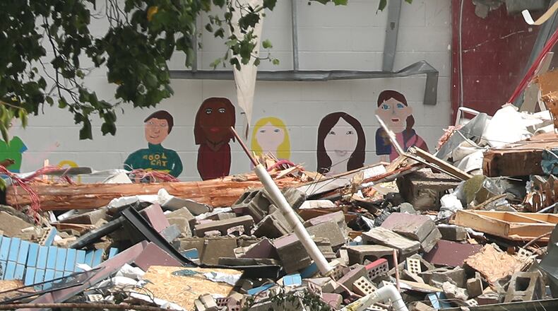 Murals painted on an interior wall at Indian Valley School peer through the rubble as the school is demolished Monday. BILL LACKEY/STAFF