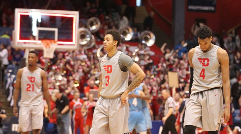 Dayton’s Dyshawn Pierre, back left, Kyle Davis and Charles Cooke react during the final seconds of a loss to Rhode Island. David Jablonski/Staff