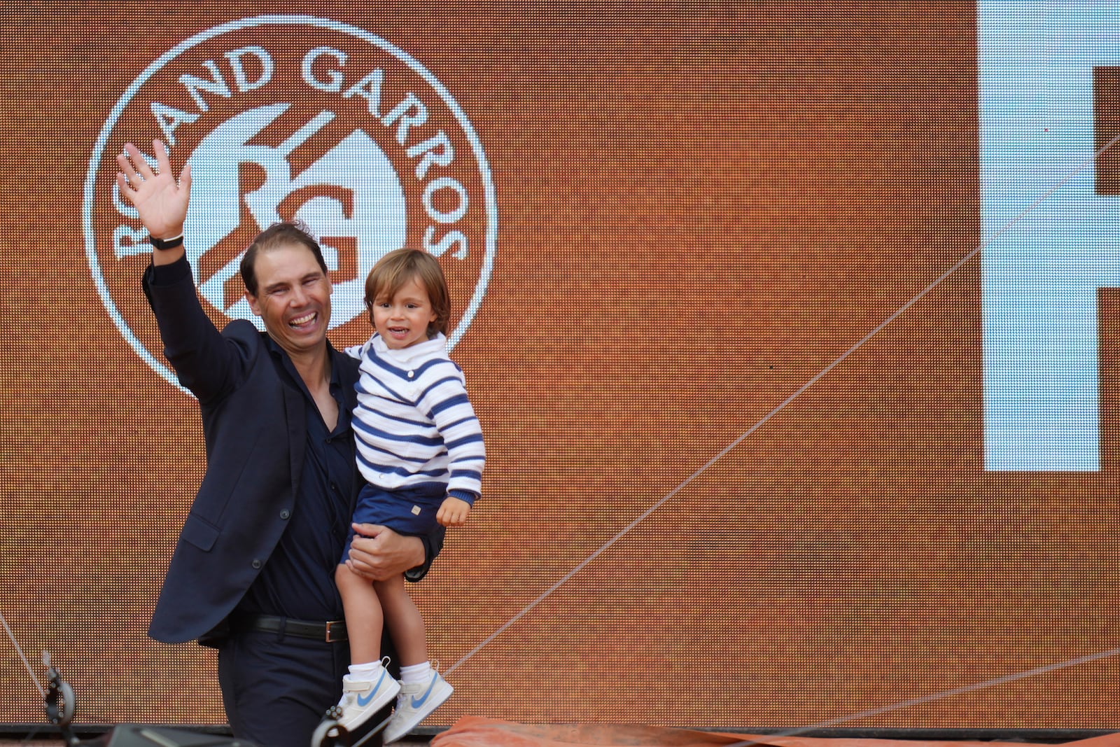 Rafa Nadal holds his son Rafael Junior during a farewell ceremony at center court Philippe-Chatrier, at the Roland-Garros stadium, in Paris, Sunday May 25, 2025. (AP Photo/Thibault Camus)