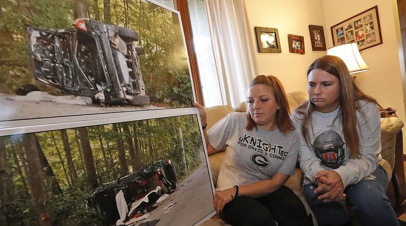 Aryn Waag, left, the mother of David Waag, and Devin Williams, the sister of Connor Williams, look over the enlarged pictures of the crash that claimed the lives of David and Connor in September. Bill Lackey/Staff