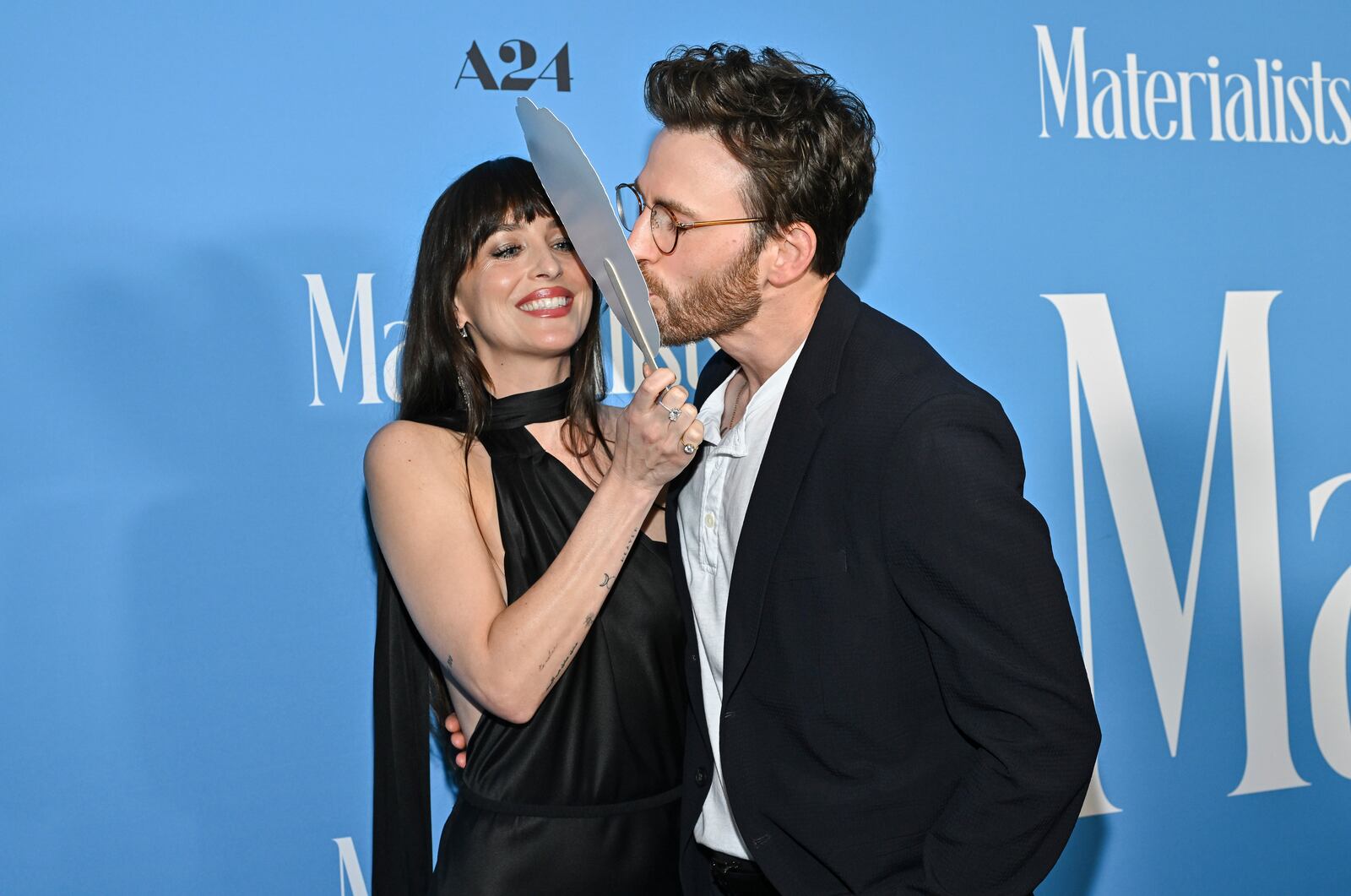 Chris Evans, right, kisses a Pedro Pascal head cutout held by Dakota Johnson at the premiere of "Materialists" at the DGA New York Theater on Saturday, June 7, 2025, in New York. (Photo by Evan Agostini/Invision/AP)