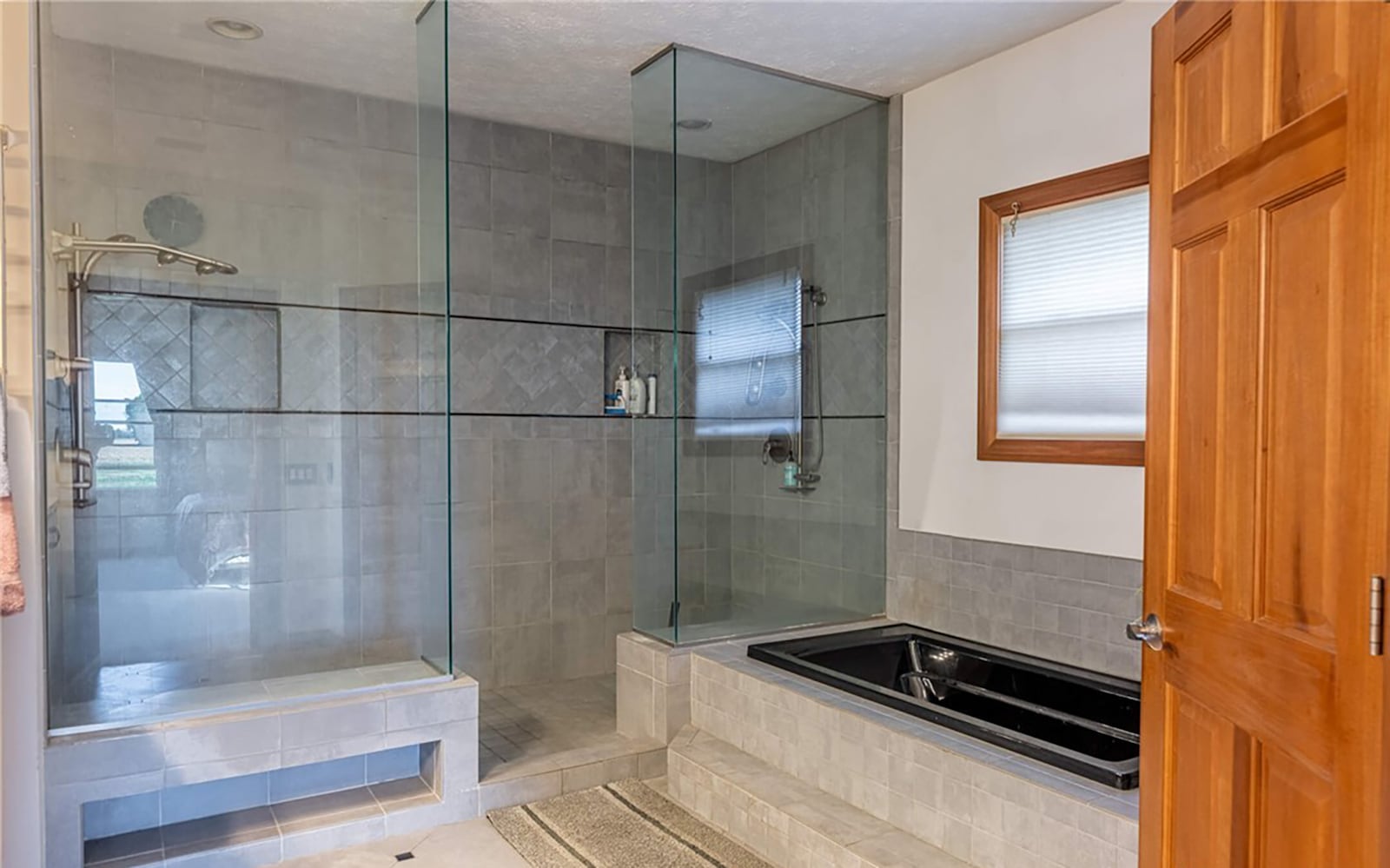 The primary ensuite bathroom features a double size tile walk in shower and an elevated soaking bathtub. CONTRIBUTED