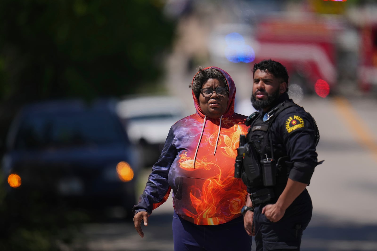 A woman arrives to a checkpoint outside Wilmer-Hutchins High School, where police are responding to reports of a shooting, in Dallas, Tx., Tuesday, April 15, 2025. (AP Photo/Julio Cortez)
