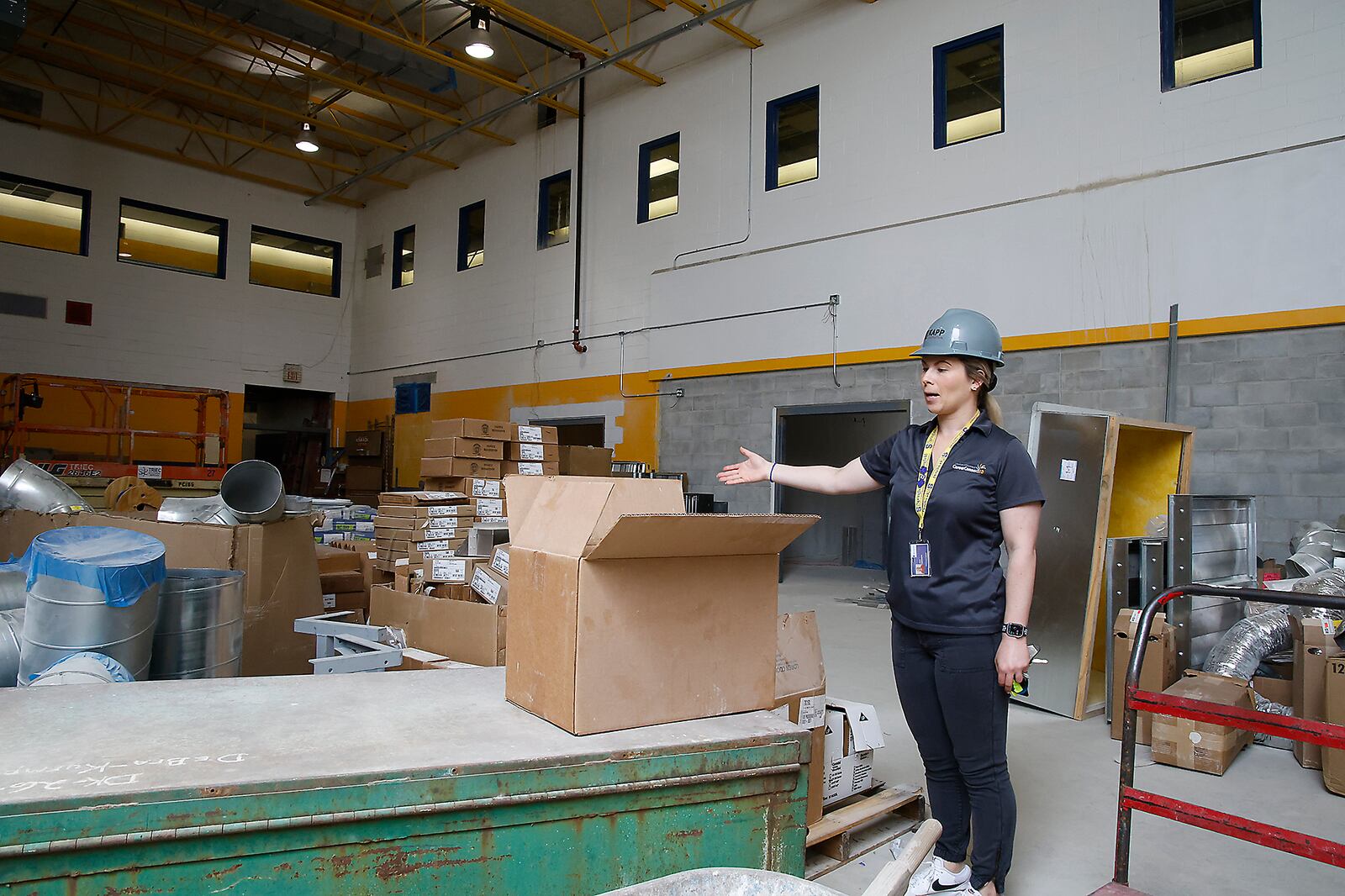 Jenna Leinasars, communications specialist at Springfield City Schools, talks about hos the former South High School weight room will be turned into manufacturing lab. BILL LACKEY/STAFF