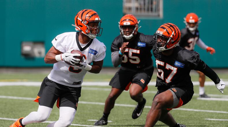 Cincinnati Bengals wide receiver Damion Willis, left, and linebacker Germaine Pratt (57) run a drill during NFL football practice, Thursday, June 13, 2019, in Cincinnati. (AP Photo/John Minchillo)