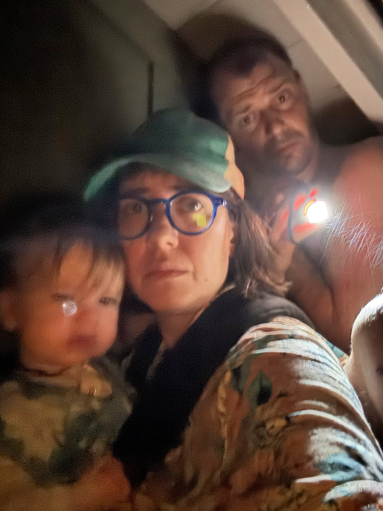 Shabd Simon-Alexander holds her one-year-old daughter, accompanied by Alden Towler, right, and Jane Towler, not pictured, on the roof of a cabin to escape floodwaters from the Guadalupe River in Hunt, Texas, at 4:48 a.m. on Friday, July 4, 2025. (Shabd Simon-Alexander via AP)