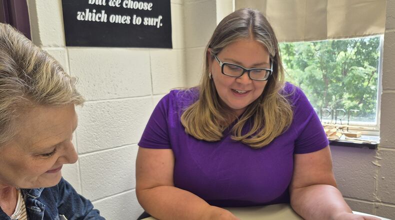Tiffany Viel (right), a high school counselor for Dayton Christian and licensed clinical counselor for Ohio, reviews files with academic advisor Renetta Hendricks. MICHAEL KURTZ/STAFF
